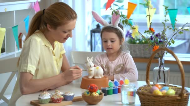 Feliz Páscoa Mãe e sua filhinha com orelhas de coelho pintando coelho da Páscoa — Vídeo de Stock