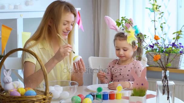 Happy Easter Mother and her little daughter coloring easter eggs — Stock Video