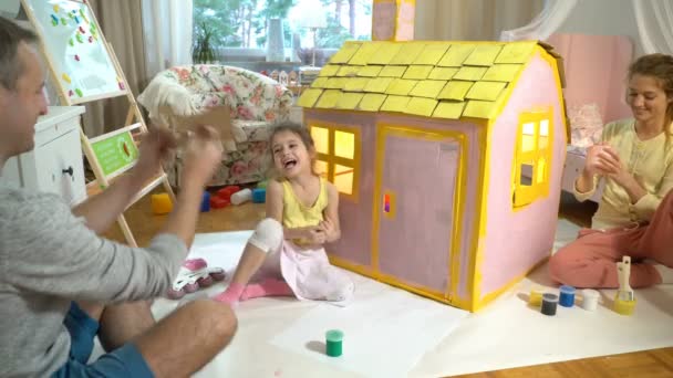父亲给快乐的小女孩一个钥匙, 她的新的纸板房子. — 图库视频影像