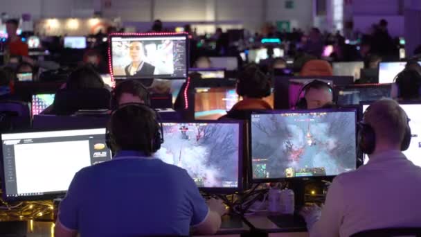 Um monte de jogadores que jogam jogos de computador no grande salão . — Vídeo de Stock