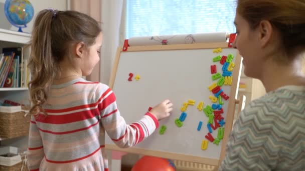 Jonge moeder uitleggen rekenkundig te schattig dochtertje thuis — Stockvideo