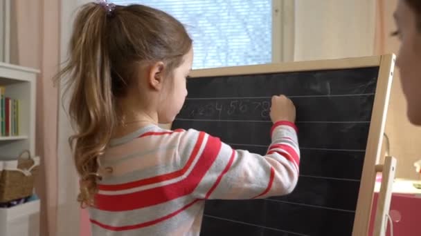 Jeune mère expliquant arithmétique à mignonne petite fille à la maison — Video