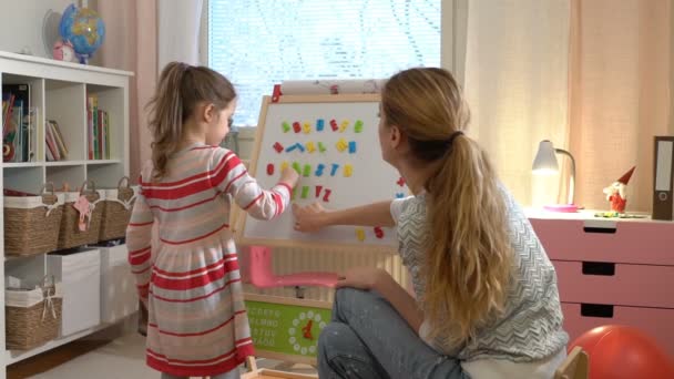 幼児の発達。若い女性が彼女の子供のアルファベットを教える. — ストック動画