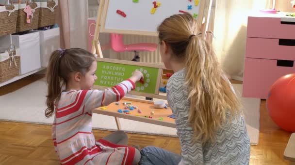 Desarrollo de la primera infancia. Niña aprendiendo tiempo con reloj de juguete en casa — Vídeos de Stock