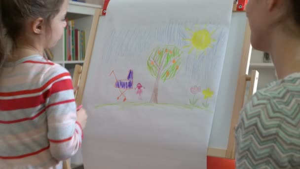 Маленька донька та її мати малюють барвистими олівцями . — стокове відео