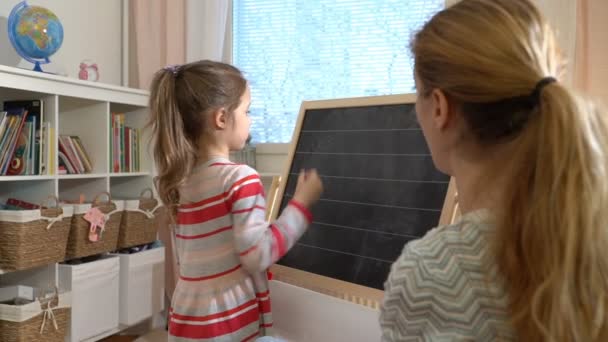 Jonge moeder uitleggen rekenkundig te schattig dochtertje thuis — Stockvideo