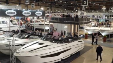 Uluslararası Boat Show. Ziyaret edenler teknelerin farklı modelleri ve fiyatları kontrol edin..