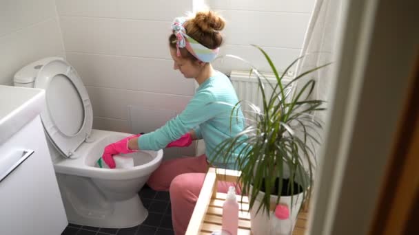 Vrouw met rubberen handschoen reinigt een toiletpot — Stockvideo