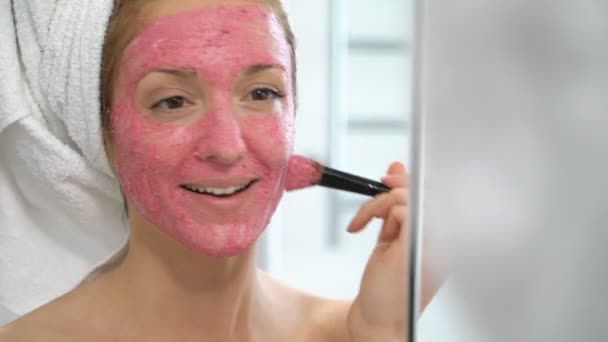 Pembe yüz nemlendirici maske olan kadın salatalık dilimleri ile çalış — Stok video