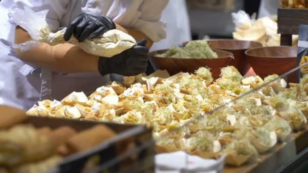Шеф-повара готовят образцы продуктов питания и лечат посетителей во время выставки — стоковое видео