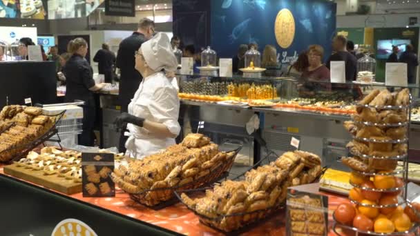Los chefs preparan muestras de comida y tratan a los visitantes durante el Food Show — Vídeos de Stock