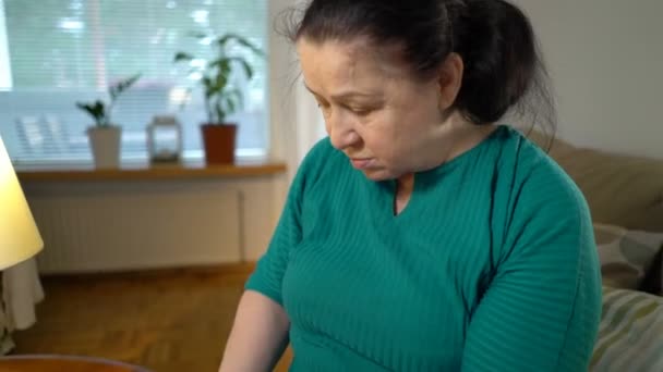 Una anciana mide la presión arterial en casa . — Vídeo de stock