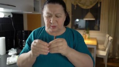 Yaşlı kadın bir baş ağrısı muzdarip ve hap alır