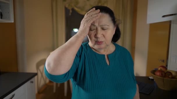 La anciana sufre de dolor de cabeza y toma pastillas. — Vídeos de Stock