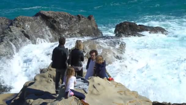 People enjoy the sun and waves on the coastal cliffs — Stock Video