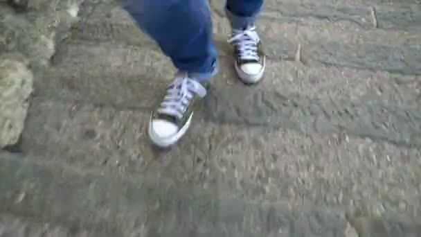 Человек в синих джинсах и кроссовках на лестнице — стоковое видео