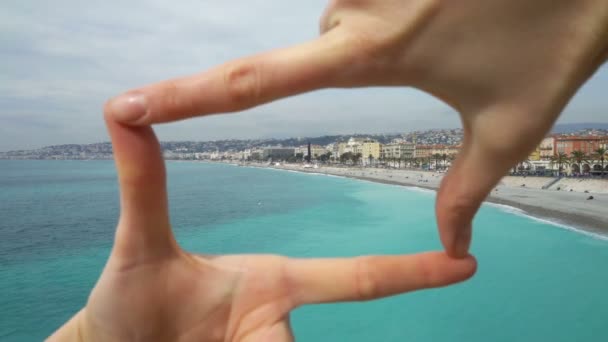 Vrouw maakt een frame met vingers op het strand op de Cote dazur Nice — Stockvideo
