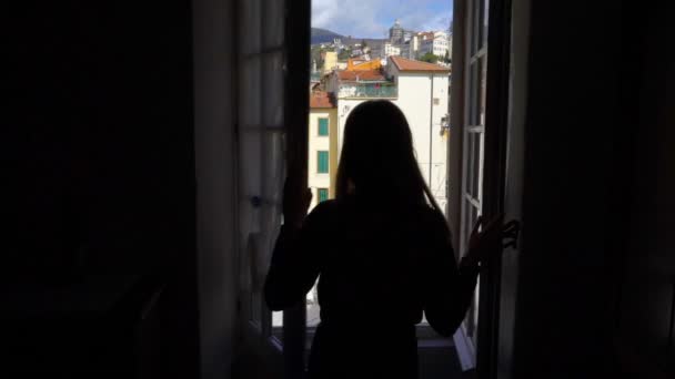 Ung kvinna öppnande fönster morgon italienska medeltida stad. — Stockvideo