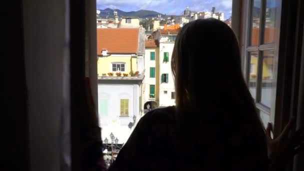 Jonge vrouw Opening venster ochtend Italiaanse middeleeuwse stad. — Stockvideo