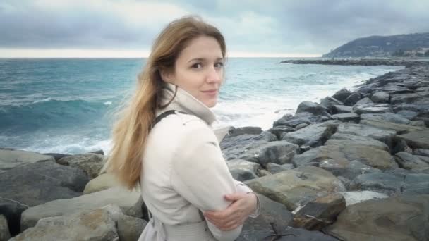 La chica se para en la playa durante la tormenta en el mar . — Vídeos de Stock