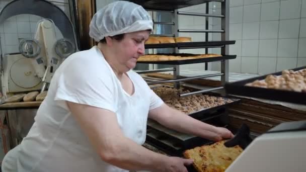 Panificio tradizionale italiano. Un fornaio donna taglia una grande torta a pezzi — Video Stock