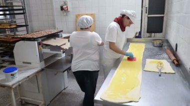 Geleneksel İtalyan fırın. İki kadın Fırıncılar krem Pasticcera, Kuru üzüm ve elma ile tatlı buns hazırlamak