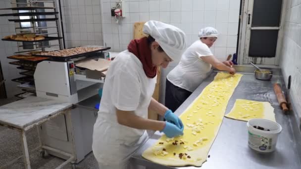 Tradycyjny włoski piekarni. Dwa kobiece piekarzy przygotować słodkie bułeczki z krem Pasticcera, rodzynki i jabłka — Wideo stockowe