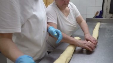 Geleneksel İtalyan fırın. İki kadın Fırıncılar krem Pasticcera, Kuru üzüm ve elma ile tatlı buns hazırlamak