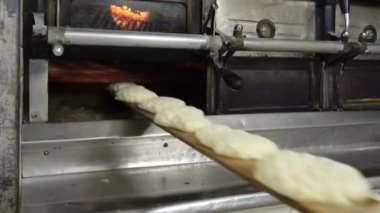 Geleneksel İtalyan fırın. Kadın Baker için özel bir uzun tahta kullanarak pişirme fırın ekmek koyar.