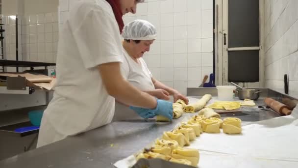 Traditional Italian bakery. Two female bakers prepare sweet buns with cream Pasticcera, raisins and apples — Stock Video