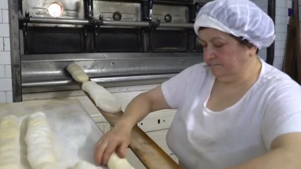 Panificio tradizionale italiano a conduzione familiare. Una donna panettiere prepara il pane per la cottura . — Video Stock