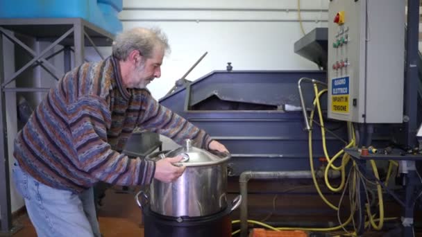 Producción de esencias de perfume por destilación de vapor en cubo de destilación en un pequeño pueblo alpino . — Vídeo de stock