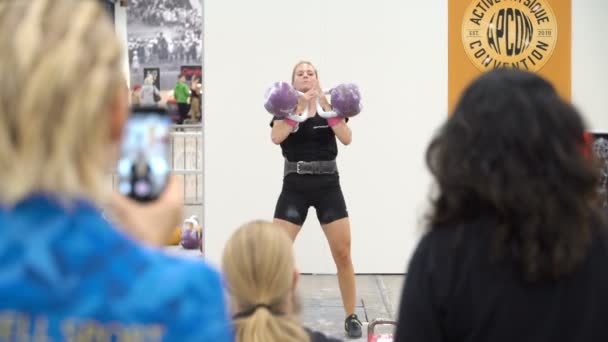 Junge entschlossene athletische Fitness-Frau, die eine schwere Kettlebells hebt. — Stockvideo