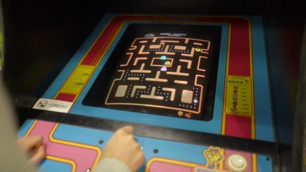 Jovem mulher jogando Pacman jogo vintage em máquinas de caça-níqueis dos anos 80 — Vídeo de Stock
