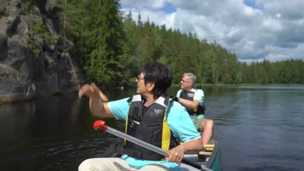 Зрелая пара каноэ на лесном озере в Финляндии . — стоковое видео