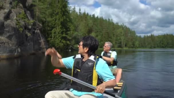 Casal maduro de canoagem em um lago florestal na Finlândia . — Vídeo de Stock