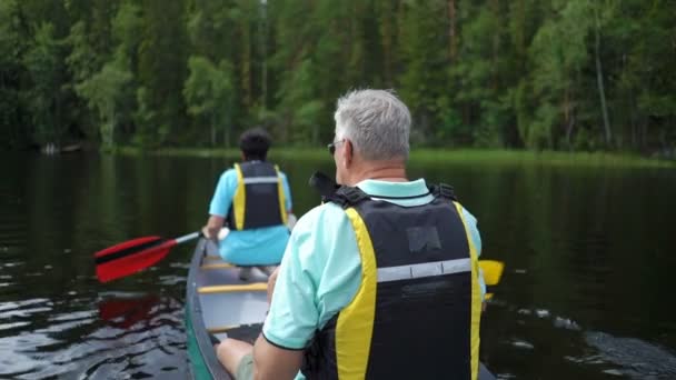 Coppia matura in canoa su un lago forestale in Finlandia . — Video Stock