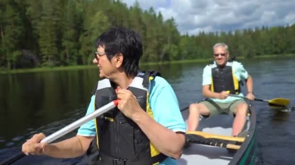 Ehepaar paddelt auf einem Waldsee in Finnland. — Stockvideo
