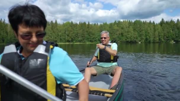 Volwassen koppel kanoën op een bos meer in Finland. — Stockvideo