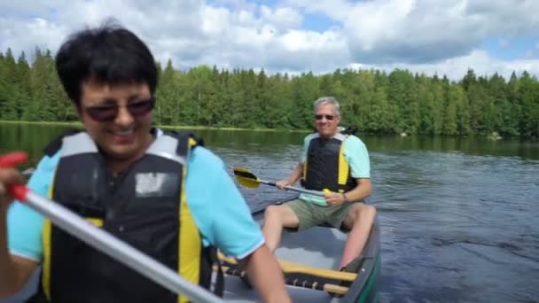 Volwassen koppel kanoën op een bos meer in Finland. — Stockvideo