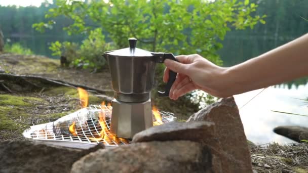 Jovem mulher fazendo café no acampamento fogo com panela moka . — Vídeo de Stock