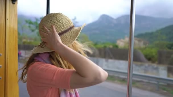 Une jeune femme appréciant voyager dans un vieux train, admirant de beaux endroits touristiques — Video