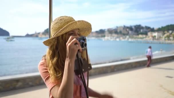 Hasır şapka giyen genç bir kadın, deniz kıyısında eski bir tramvay da ya da trende seyahat etmekten keyif alıyor. — Stok video