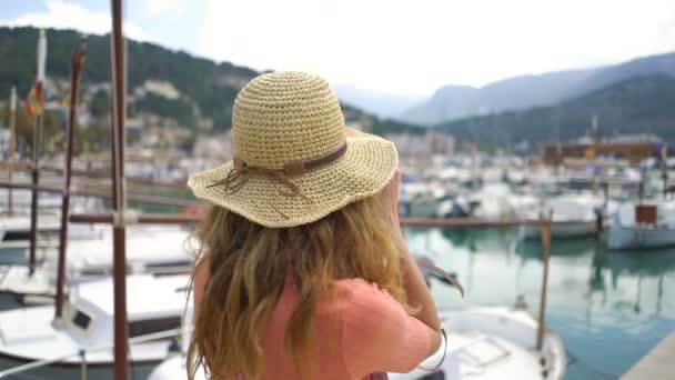 Portret van jonge vrouw dragen stro hoed glimlachend op de camera Seacoast achtergrond. — Stockvideo