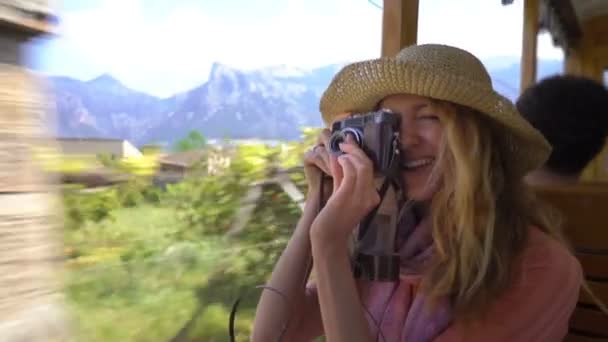 Eine junge Frau genießt die Fahrt in einem alten Zug und bewundert schöne Touristenorte — Stockvideo