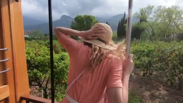 Egy fiatal nő élvezi utazik egy régi vonaton, megcsodáló gyönyörű turisztikai helyszínek — Stock videók