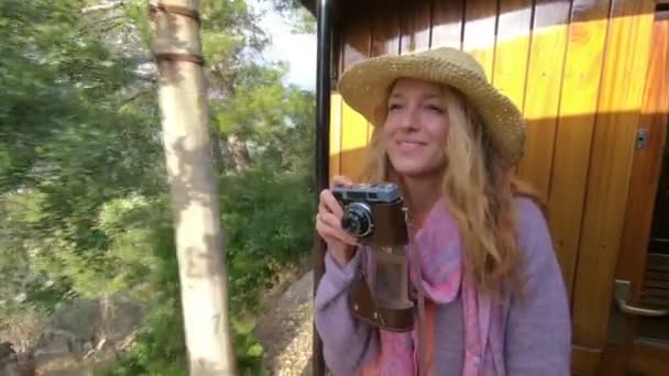 A young woman in a straw hat enjoying traveling on an old train — Stock Video