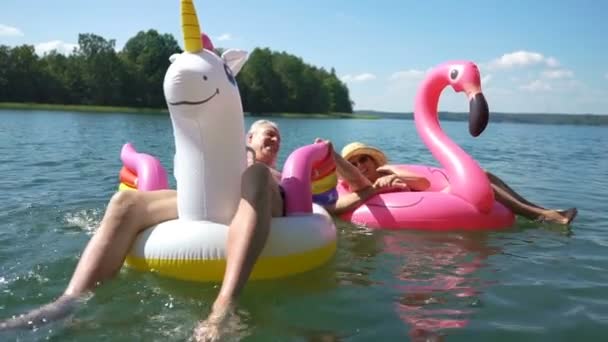 Casal de idosos flutuando no flamingo inflável e no unicórnio . — Vídeo de Stock