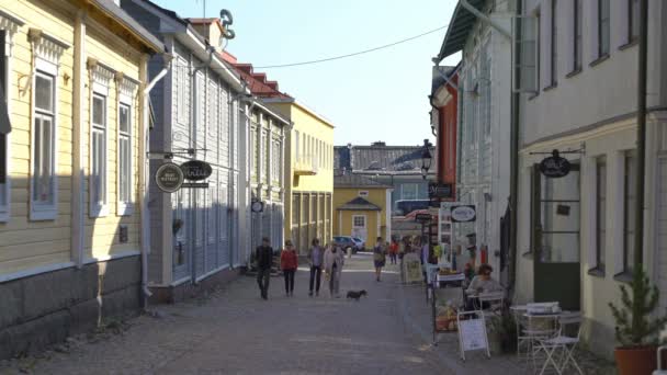 Una gran cantidad de turistas caminando por las tiendas a lo largo de las calles empedradas de la sección medieval del casco antiguo de Porvoo, Finlandia . — Vídeos de Stock