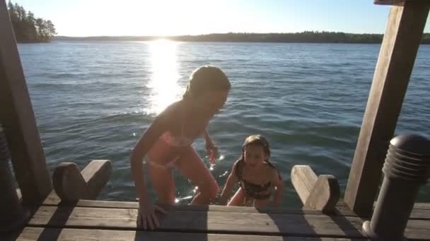 Une jeune femme mince avec sa fille nageant dans le lac — Video